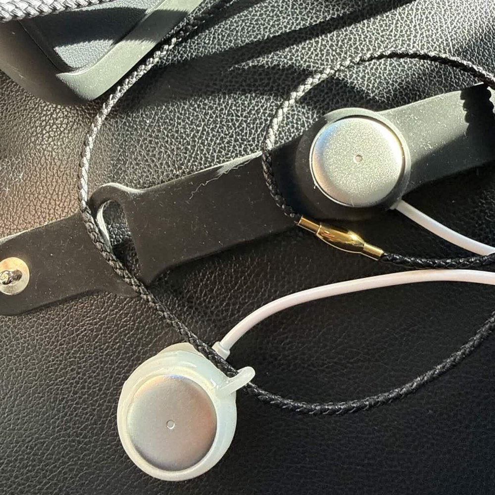 Two Omi pendants on their cords on a car seat